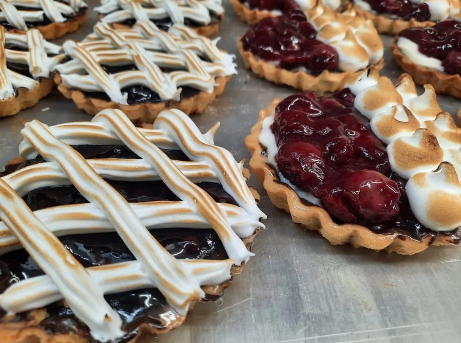 Bäckerei Konditorei Neher Rettenberg - Backwaren und Lebensmitteln - Mini-Heidelbeerkuchen, oft auch Törtchen genannt, mit einem blättrigen Teigboden und einer reichhaltigen, dunklen Heidelbeerfüllung.